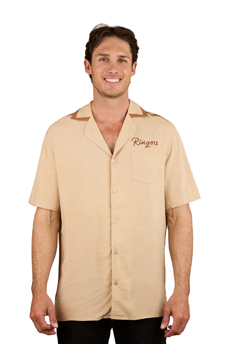 A man smiles wearing the Ringers Western Mens Carter S/S Pub Shirt (125002RW) in Dark Sand, featuring a brown collar, short sleeves, and "Ringers" embroidered on the left chest pocket. The background is plain white.