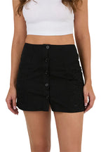 A woman wears a white sleeveless crop top paired with the Ringers Western Womens Jynette Button Down Mini Skirt in black, featuring a high-waisted fit, front buttons, and subtle floral embroidery from Ringers Western.