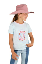 A young girl in a pale pink cowboy hat, blue jeans, and the Ringers Western Girls Raised On Country Music Classic Fit S/S Tee (Barely Blue) smiles and looks off to the side with one hand in her pocket against a white background.