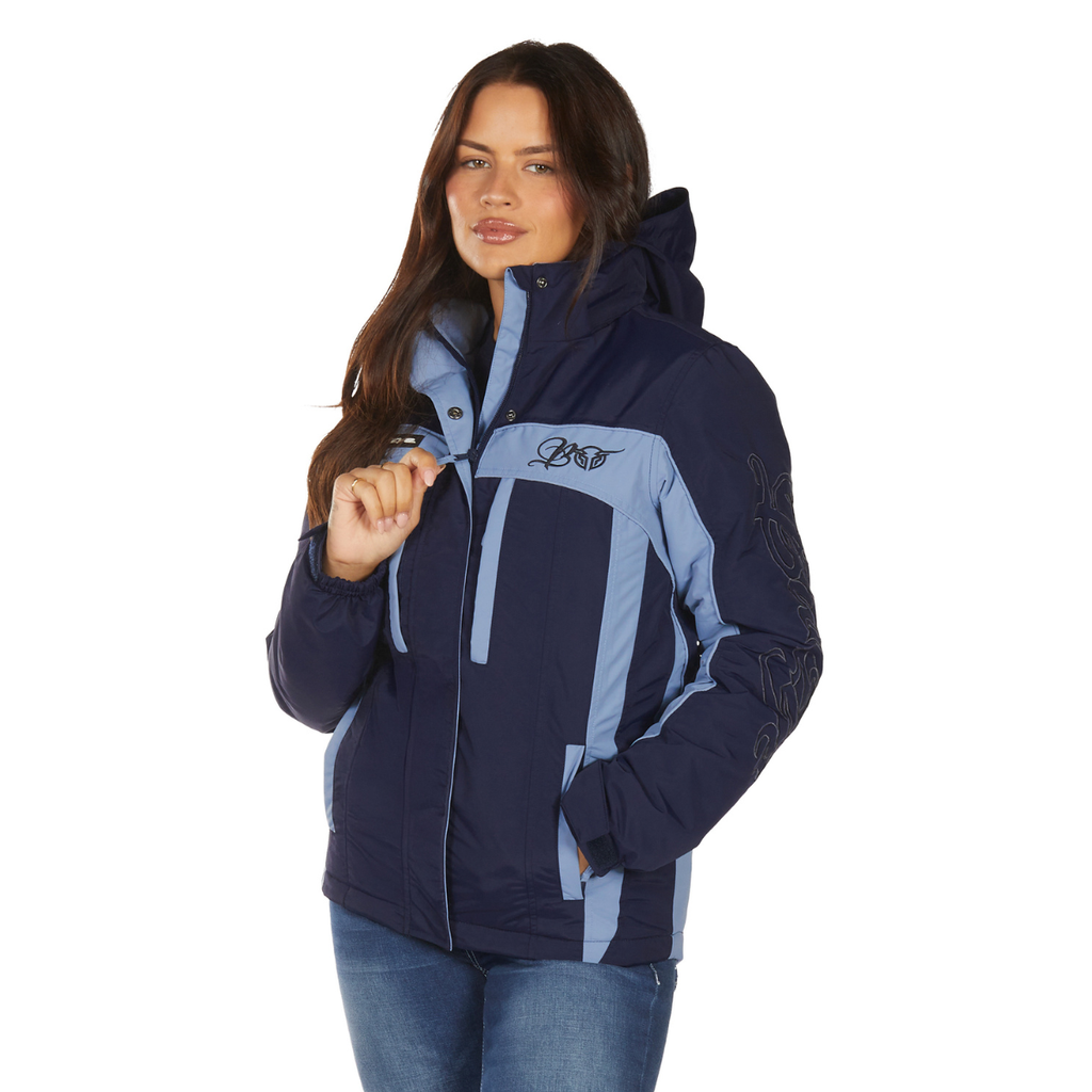 A woman with long dark hair wears the Bullzye Womens Carla Jacket (B6W2709529) in Light Blue/Navy by Bullzye, paired with blue jeans, standing against a white background.