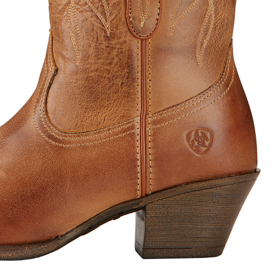 Close-up of a brown leather cowboy boot with decorative stitching, a curved side seam, and a low angled heel, featuring a small embossed logo near the ankle.