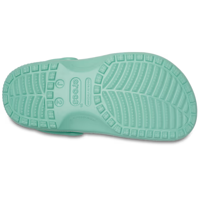 The bottom sole of a single retro mint Crocs Children's Classic Clog (206991-5DV), showing the textured tread pattern and embossed brand logo, on a solid white background.