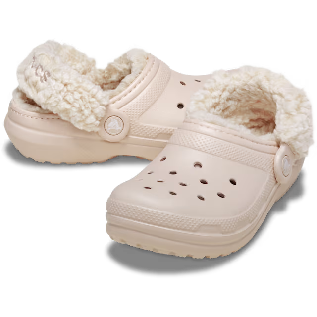 A pair of Crocs Children's Classic Fleece Lined Clogs (212856-6UR) in a quartz colour, featuring a plush cream sherpa lining inside and a matching textured strap with a circular logo button.