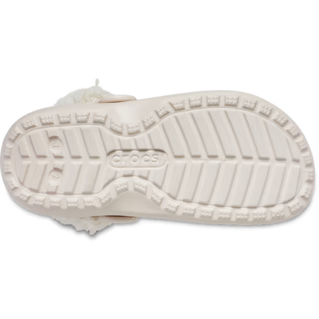 The bottom sole of a quartz coloured Crocs Children's Classic Fleece Lined Clog (212856-6UR) featuring the embossed Crocs logo in the centre and a textured tread pattern.