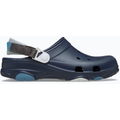 The Crocs Unisex All Terrain Clogs (206340-410) Navy by Crocs features ventilation holes, a white and brown adjustable heel strap, and blue and white traction patches on the sole, shown in side profile.
