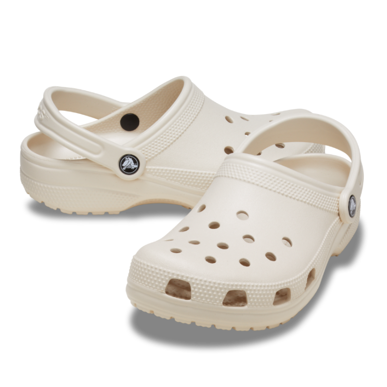 The Crocs Unisex Classic Clogs (10001-2MC) Frappe by Crocs are beige clogs with ventilation holes and adjustable heel straps, shown on a white background. Lightweight and comfortable, they’re ideal water-friendly footwear for daily use.