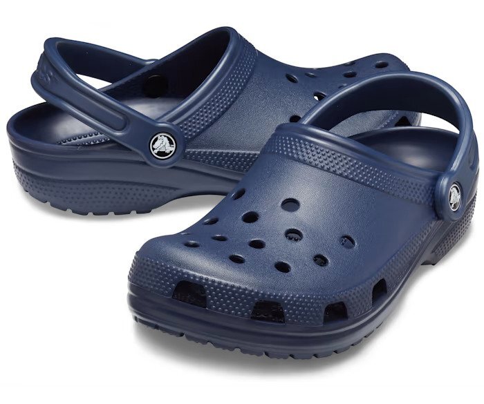 Crocs Unisex Classic Clogs (10001-410) in Navy by Crocs, shown on a white background, feature ventilation holes and adjustable heel straps for comfort. These water-friendly clogs are practical for everyday wear.