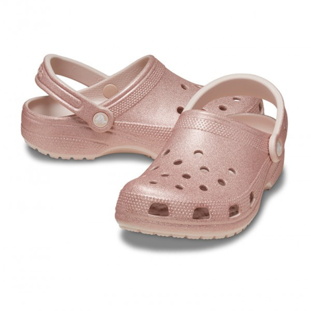 The Crocs Unisex Classic Glitter Clogs (205942-6WV) in Quartz Glitter feature light pink glitter, ventilation holes, and adjustable heel straps, offering comfort and style from Crocs—all shown here on a white background.