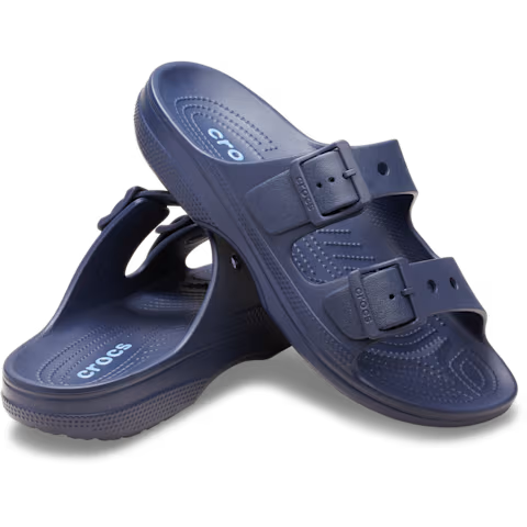 Crocs Mens Saturday Sandals (212245-410) in navy by Crocs feature two adjustable straps per shoe, textured footbeds for comfort, and a side logo. One sandal stands upright while the other leans against it.