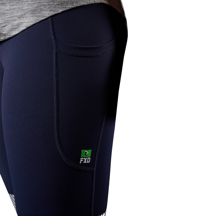 A close up view of the pocket of a pair of navy FXD Women's Taped Work Leggings (WP-9WT) paired with a grey tee on a white background.