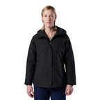 A woman modelling a black hooded FXD Women's WO-1W Insulated Waterproof Jacket (FX12407001) with a full front zipper and zippered chest pocket, paired with dark blue pants, against a solid white background.
