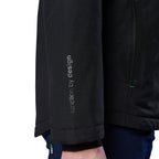 Close-up of a woman modelling a black hooded FXD Women's WO-1W Insulated Waterproof Jacket (FX12407001) sleeve with vertical text reading 'function by design' worn with dark blue pants against a white background.