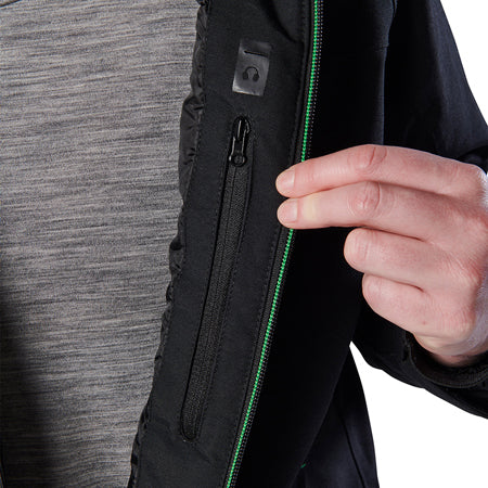 Close-up of a woman modelling a black hooded FXD Women's WO-1W Insulated Waterproof Jacket (FX12407001) with a green zipper accent, featuring a hand holding it open to show the inner zipper detail.