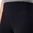 A close up of the front waist of a woman modelling a pair of black FXD Women's Work Leggings (WP-9W) against a white background.