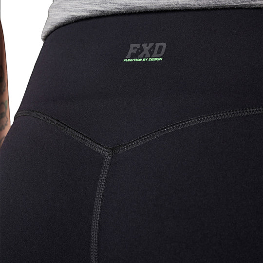 A close up of the back waist of a woman modelling a pair of black FXD Women's Work Leggings (WP-9W) against a white background.
