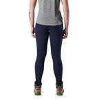 A woman viewed from behind modelling a pair of navy blue FXD Women's Work Leggings (WP-9W) paired with a grey tee and stone coloured work boots on a white background.