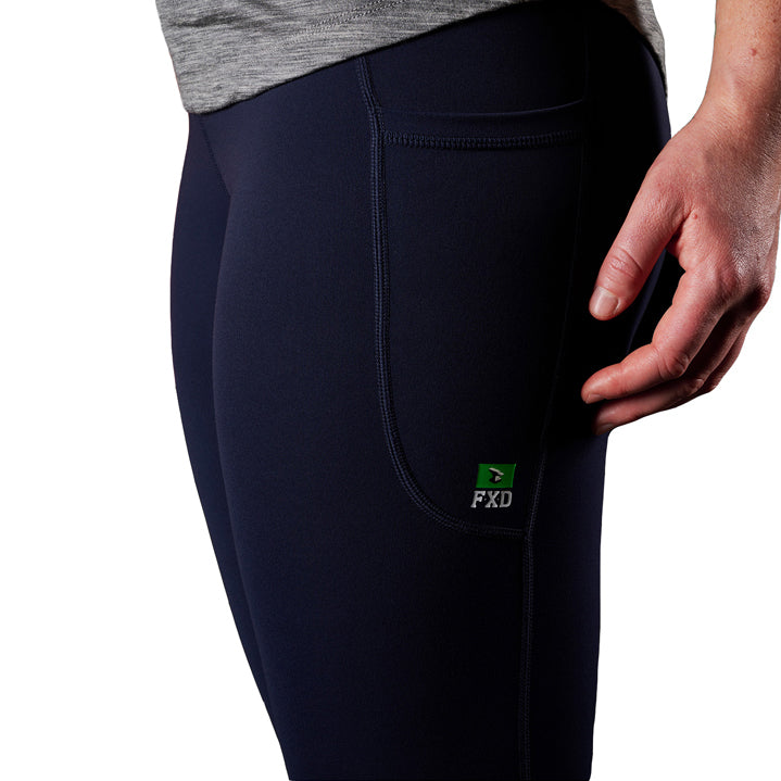 A close up of the pocket detail on a pair of navy blue FXD Women's Work Leggings (WP-9W) paired with a grey tee on a white background.