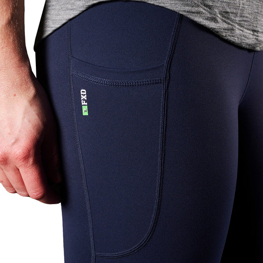 A close up of the pocket detail on a pair of navy blue FXD Women's Work Leggings (WP-9W) paired with a grey tee on a white background.