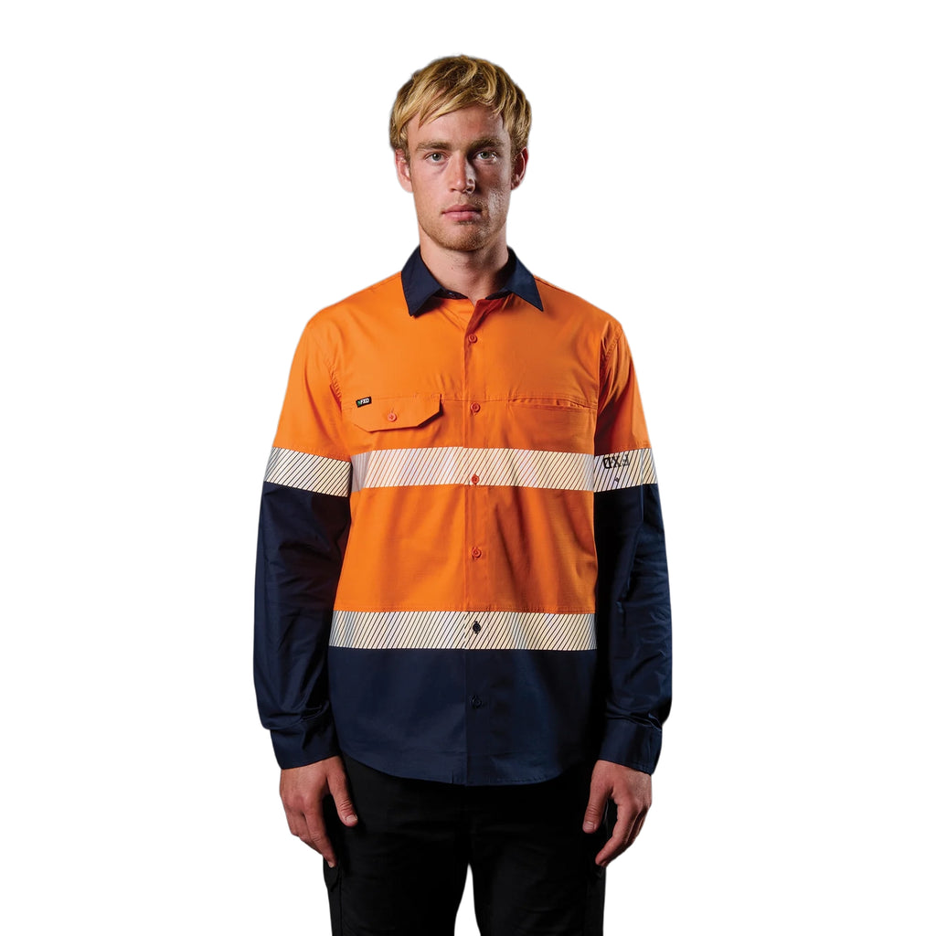 A man wearing an orange and navy FXD Men's LSH-4T Vented Tech Hi-Vis Long Sleeve Work Shirt (FX02504010) with hi vis tape and a pair of black work pants on a white background.