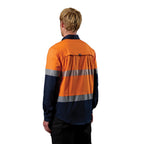 A 3-4 back left view of a man wearing an orange and navy FXD Men's LSH-4T Vented Tech Hi-Vis Long Sleeve Work Shirt (FX02504010) with hi vis tape and a pair of black work pants on a white background.