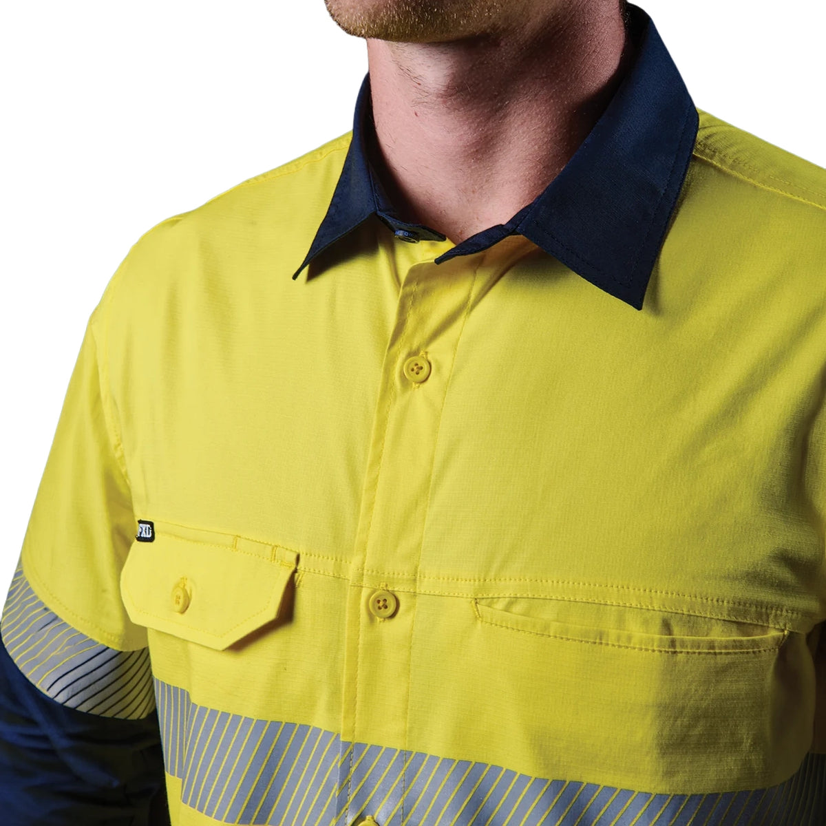 Close up detail of a yellow and navy FXD Men's LSH-4T Vented Tech Hi-Vis Long Sleeve Work Shirt (FX02504010) with hi vis tape on a white background.