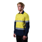 A 3-4 left view of a man wearing a yellow and navy FXD Men's LSH-4T Vented Tech Hi-Vis Long Sleeve Work Shirt (FX02504010) with hi vis tape and a pair of black work pants on a white background.