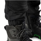 Cuff detail of a pair of black cargo style FXD WP-12C Elastic Waist Stretch Ripstop Cuffed Work Pants (FX02506027) and black work boots, on a plain white studio background.