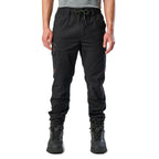 A man wearing black cargo style FXD WP-12C Elastic Waist Stretch Ripstop Cuffed Work Pants (FX02506027) with a drawstring waist and black work boots, shown from the waist down on a plain white studio background.