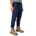 A 3-4 front view of a man wearing navy cargo style FXD WP-12C Elastic Waist Stretch Ripstop Cuffed Work Pants (FX02506027) with a drawstring waist and stone work boots, shown from the waist down on a plain white studio background.