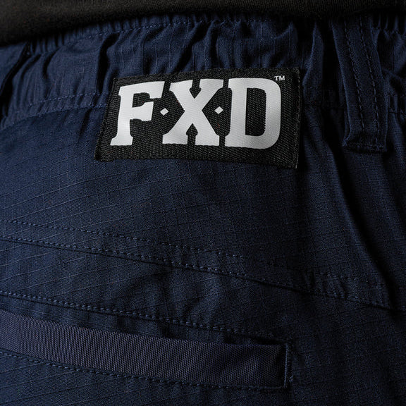 A close up on a model showing the back waist detail on a pair of navy FXD Men's WP-12CT Elastic Waist Stretch Ripstop Cuffed Taped Work Pants (FX02606029).