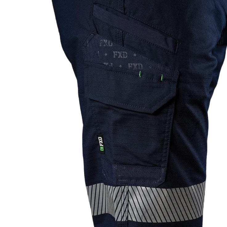 A close up of a model showing the pocket and tape detail on a pair of navy FXD Men's WP-12CT Elastic Waist Stretch Ripstop Cuffed Taped Work Pants (FX02606029) on a white background.