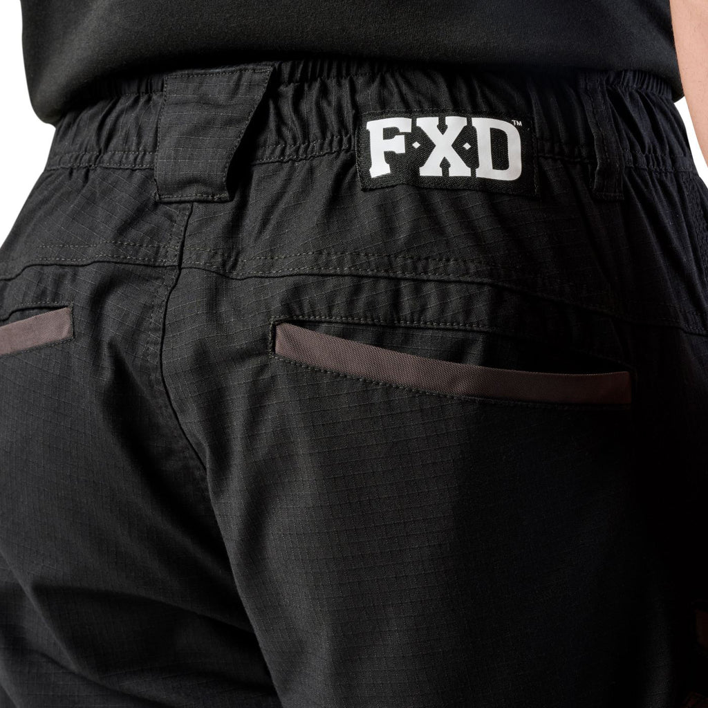 A close up of the back waist pocket detail on a pair of black cargo style FXD Men's WP-12 Elastic Waist Stretch Ripstop Work Pants (FX02506026) on a white background.