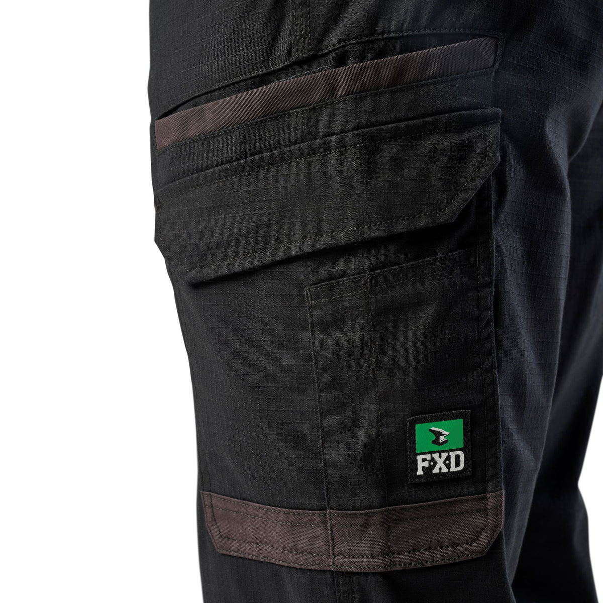 A close up of the pocket detail on a pair of black cargo style FXD Men's WP-12 Elastic Waist Stretch Ripstop Work Pants (FX02506026) on a white background.