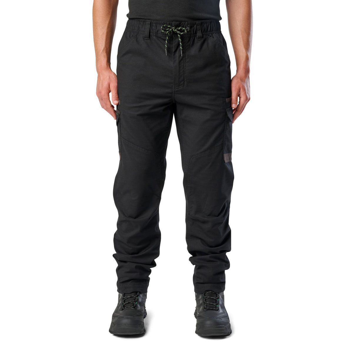 A man wearing black cargo style FXD Men's WP-12 Elastic Waist Stretch Ripstop Work Pants (FX02506026) with black work boots on a white background.