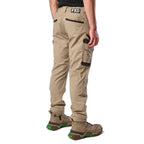 A 3-4 back view of a man wearing khaki cargo style FXD Men's WP-12 Elastic Waist Stretch Ripstop Work Pants (FX02506026) with stone coloured work boots on a white background.