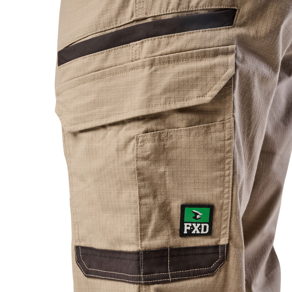 Close up of the pocket detail of a pair of khaki cargo style FXD Men's WP-12 Elastic Waist Stretch Ripstop Work Pants (FX02506026) on a white background.