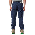 A back view of a man wearing navy blue cargo style FXD Men's WP-12 Elastic Waist Stretch Ripstop Work Pants (FX02506026) with stone coloured work boots on a white background.