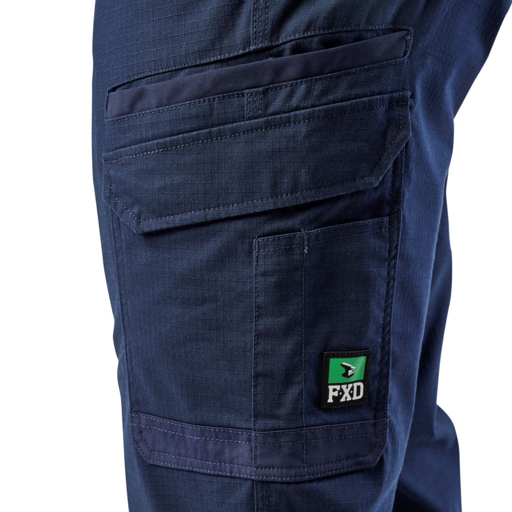 A close up of the pocket detail on a pair of navy blue cargo style FXD Men's WP-12 Elastic Waist Stretch Ripstop Work Pants (FX02506026) on a white background.