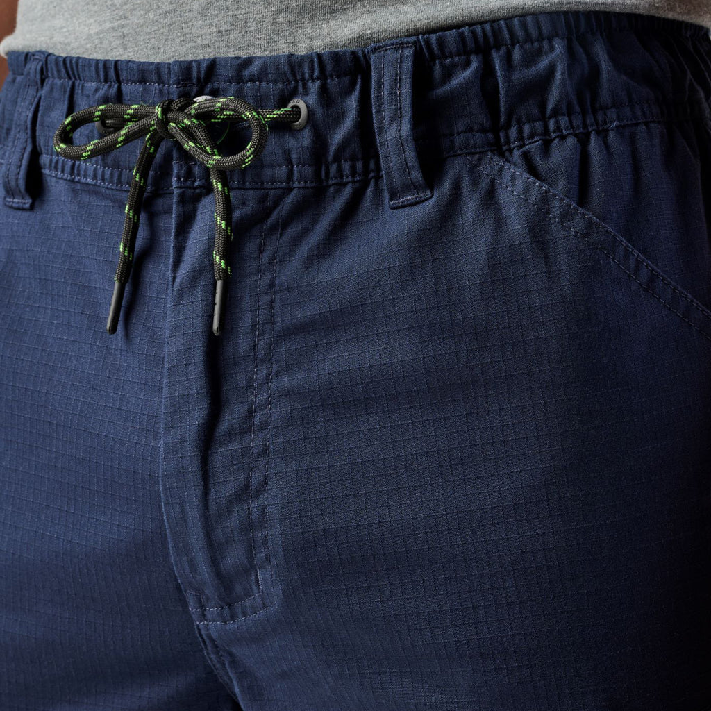 Close up waist detail of a pair of navy blue cargo style FXD Men's WP-12 Elastic Waist Stretch Ripstop Work Pants (FX02506026) on a white background.
