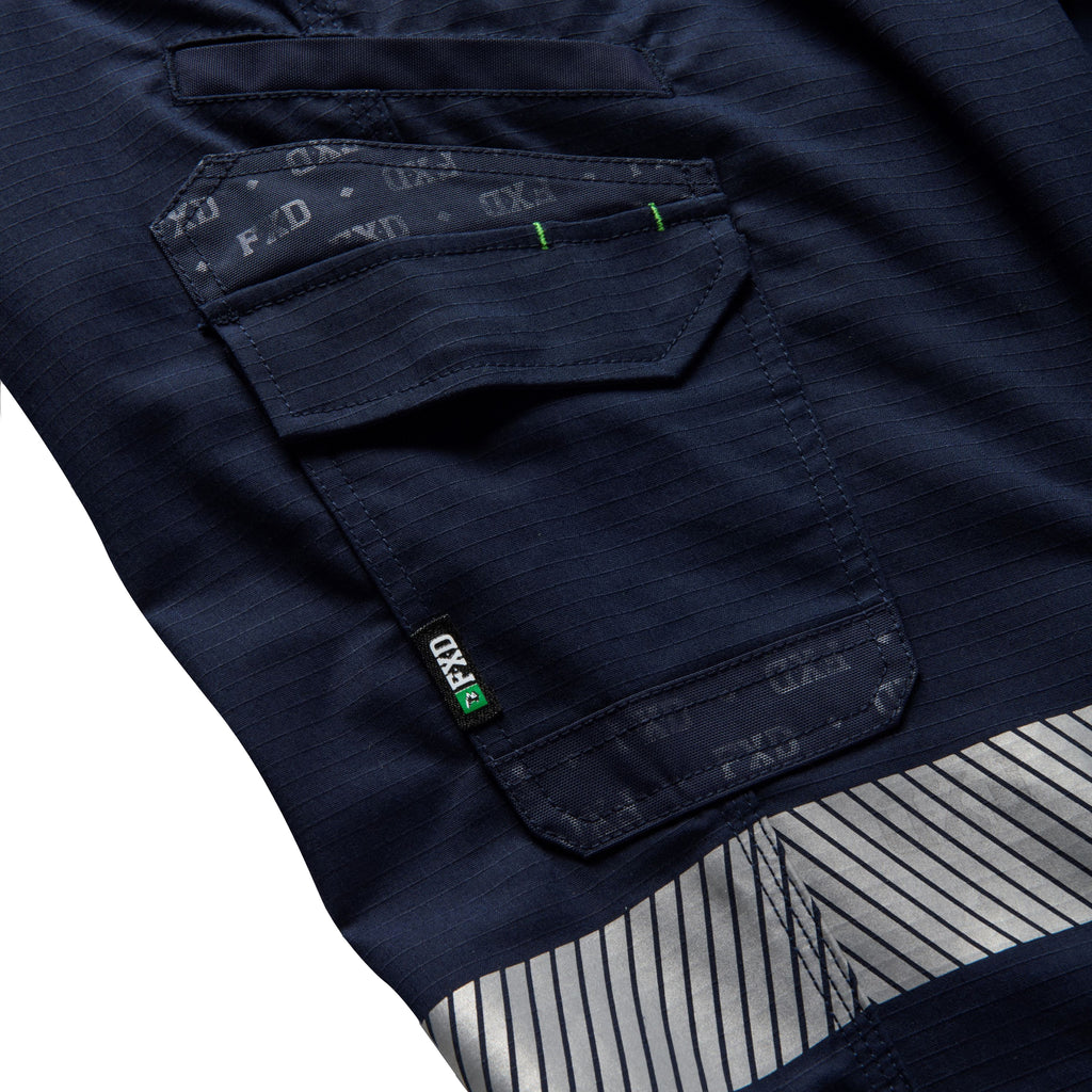 Close up flat lay of pocket detail of a pair of navy blue FXD Men's WP-12T Elastic Waist Stretch Ripstop Taped Work Pants (FX02606028) on a white background.