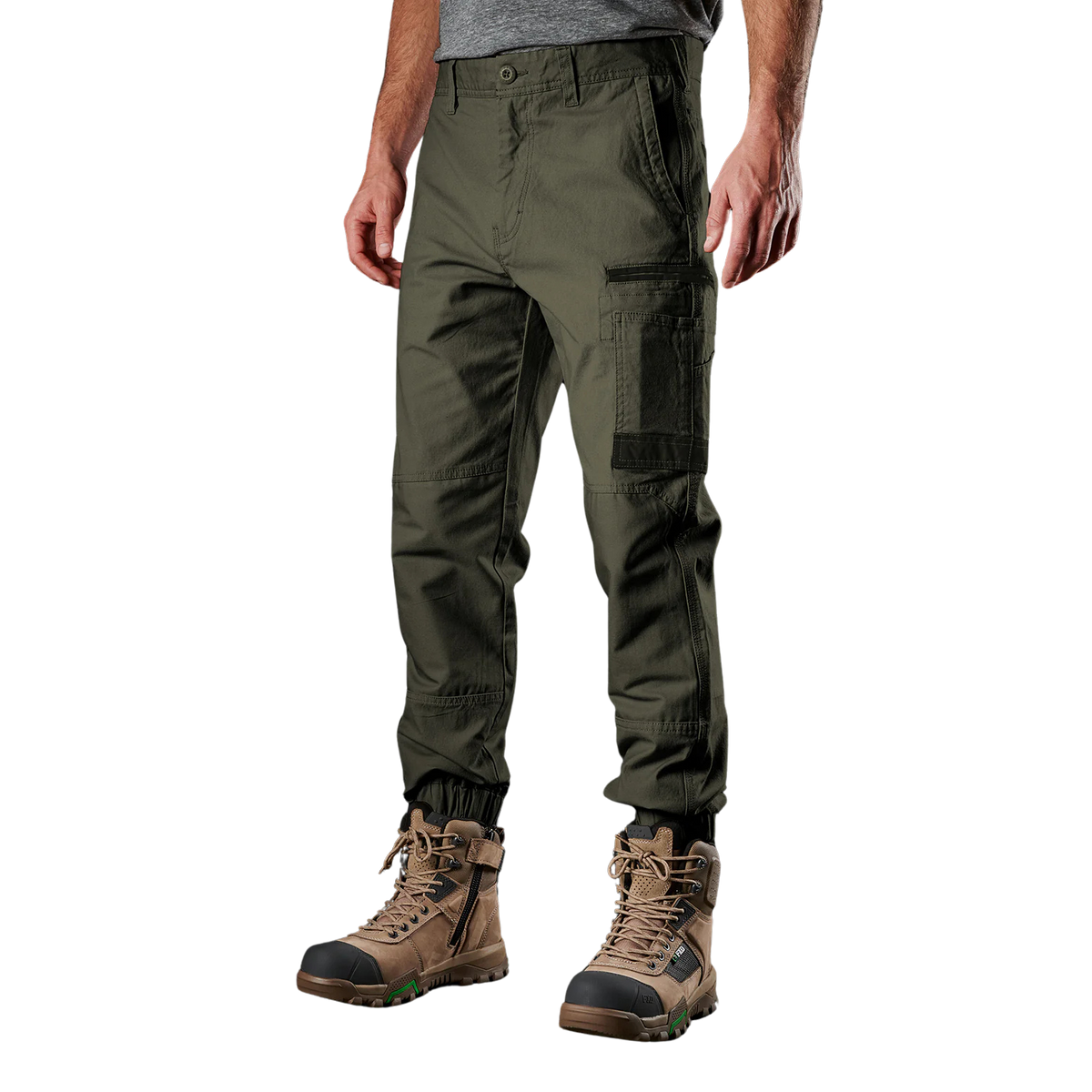 A man wearing green FXD Men's WP-4 Stretch Cuffed Work Pants (FX01616003) with cargo pockets and elastic cuffed ankles, paired with wheat coloured work boots, shown against a plain white background.
