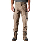 A man wearing khaki FXD Men's WP-4 Stretch Cuffed Work Pants (FX01616003) with cargo pockets and elastic cuffed ankles, paired with wheat coloured work boots, shown against a plain white background.