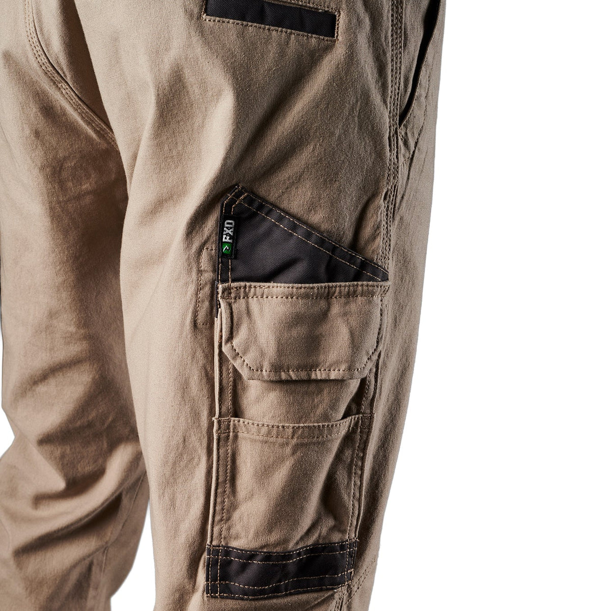 Close up pocket detail on a pair of khaki FXD Men's WP-4 Stretch Cuffed Work Pants (FX01616003) with cargo pockets, shown against a plain white background.