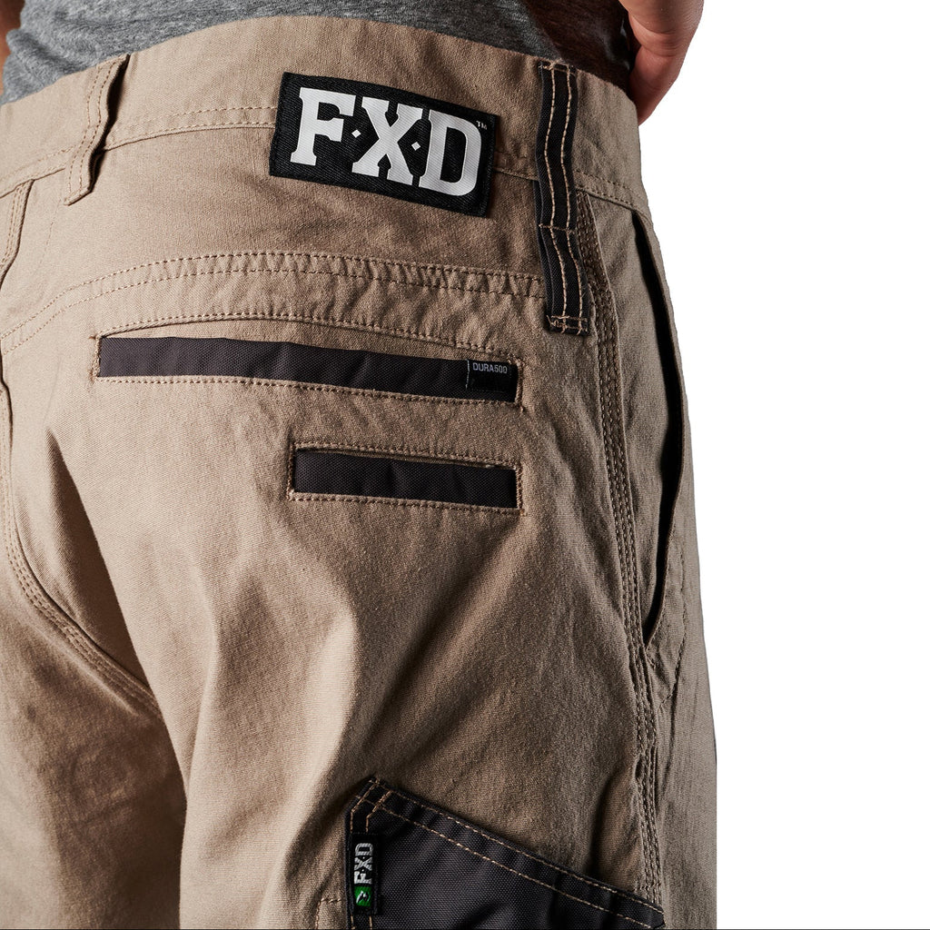 Close up waist and pocket detail on a pair of khaki FXD Men's WP-4 Stretch Cuffed Work Pants (FX01616003) with cargo pockets, shown against a plain white background.