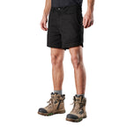 A man from the waist down wearing black FXD Men's WS-2 Work Shorts (FX01136005), grey socks, and stone FXD work boots against a solid white background.