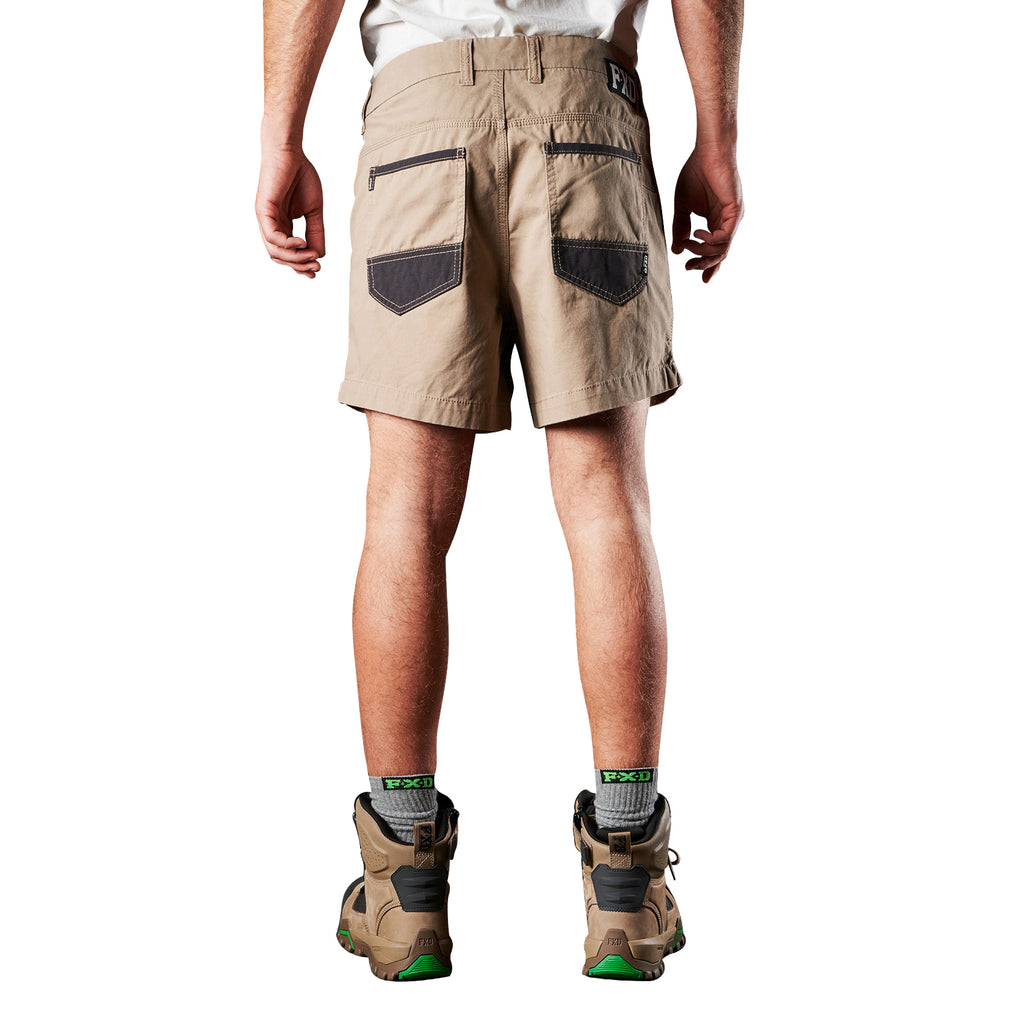 A back view of a man modelling a pair of khaki FXD Men's WS-2 Work Shorts (FX01136005) paired with grey socks, and stone FXD work boots against a plain white background.