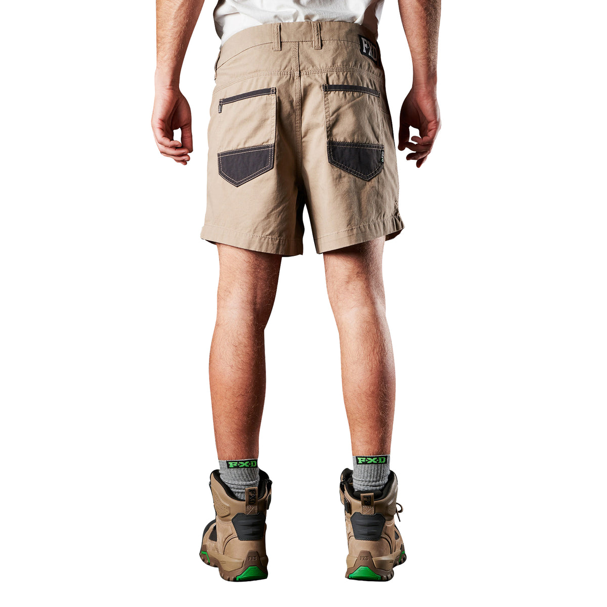 A back view of a man modelling a pair of khaki FXD Men's WS-2 Work Shorts (FX01136005) paired with grey socks, and stone FXD work boots against a plain white background.