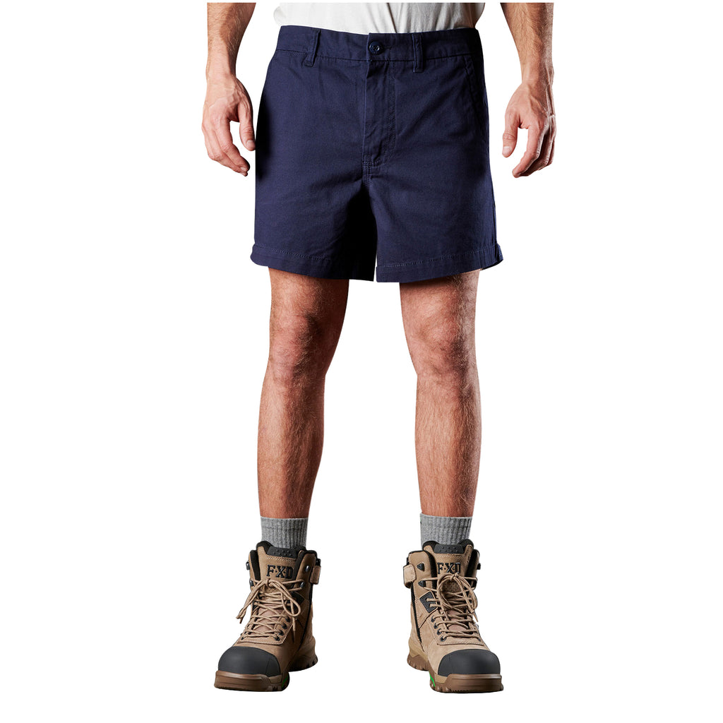 A man modelling navy blue FXD Men's WS-2 Work Shorts (FX01136005), paired with grey socks, and stone FXD work boots, shown from the waist down on a plain white background.