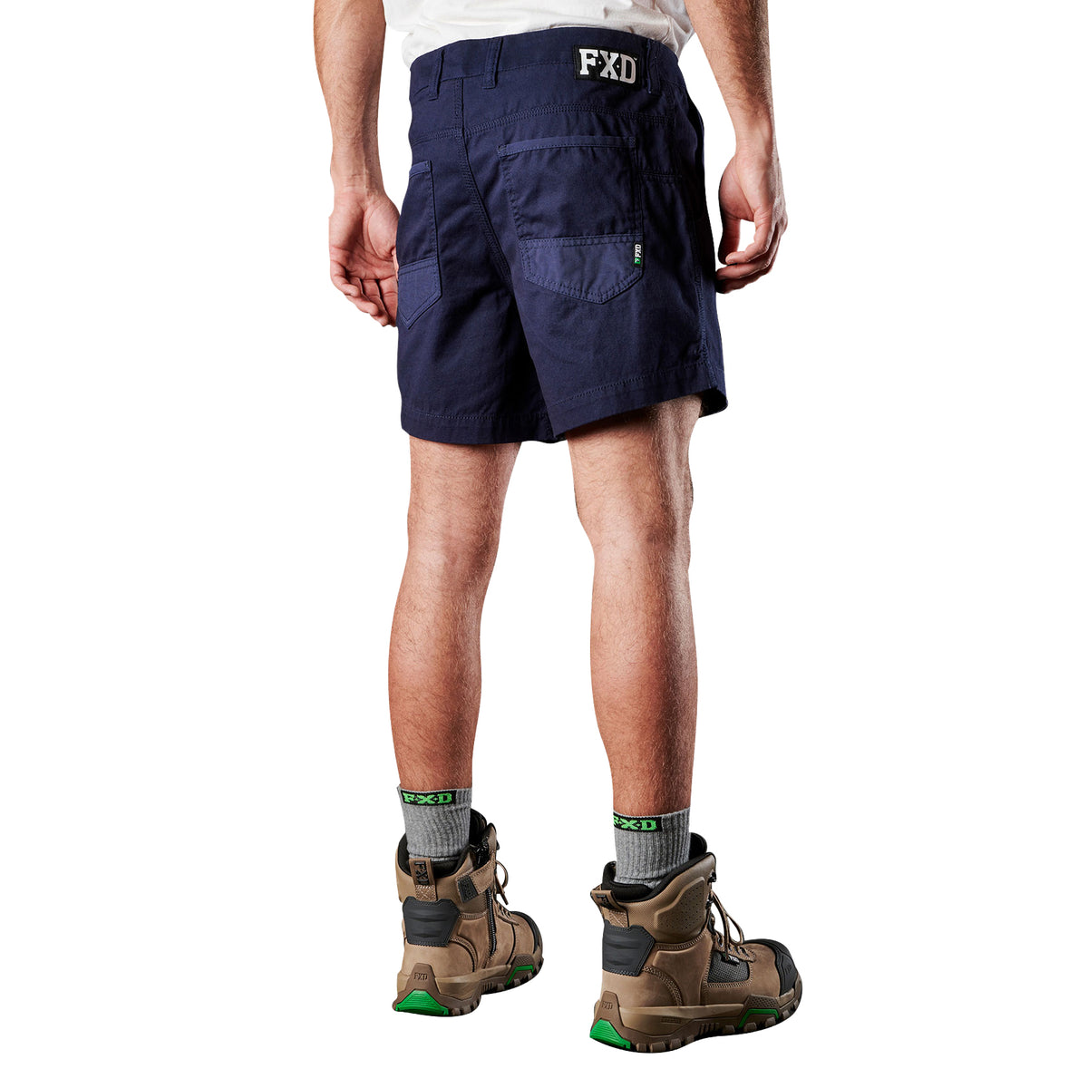A man viewed from behind, modelling navy blue FXD Men's WS-2 Work Shorts (FX01136005), paired with grey socks, and stone FXD work boots, shown from the waist down on a plain white background.