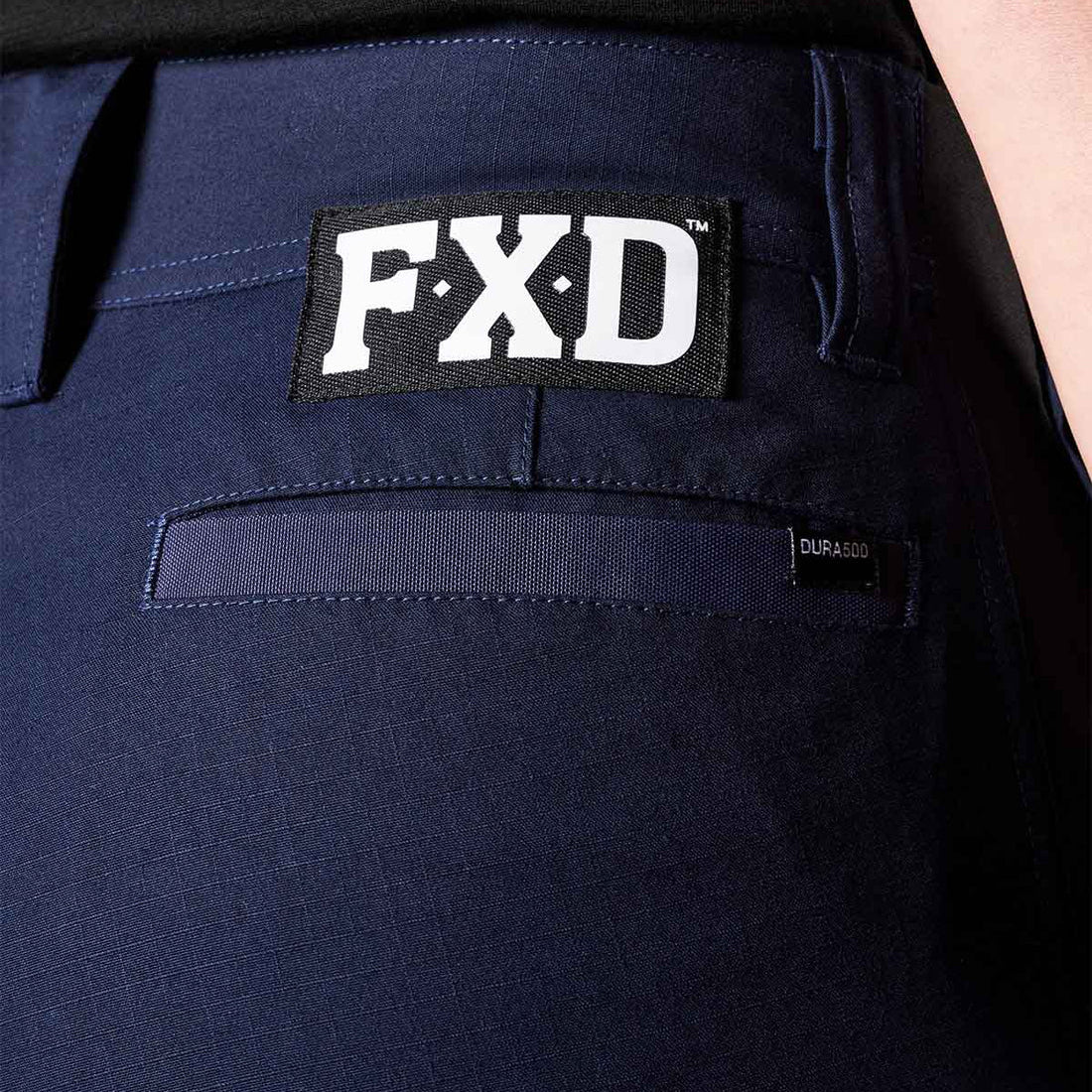 A close up view of the back waist of a pair of navy blue FXD Women's Cuffed Taped Work Pants (WP-8WT) paired with a black t-shirt.